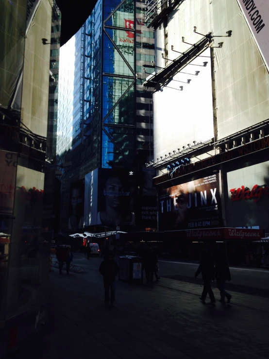 people walk on the sidewalk next to tall buildings