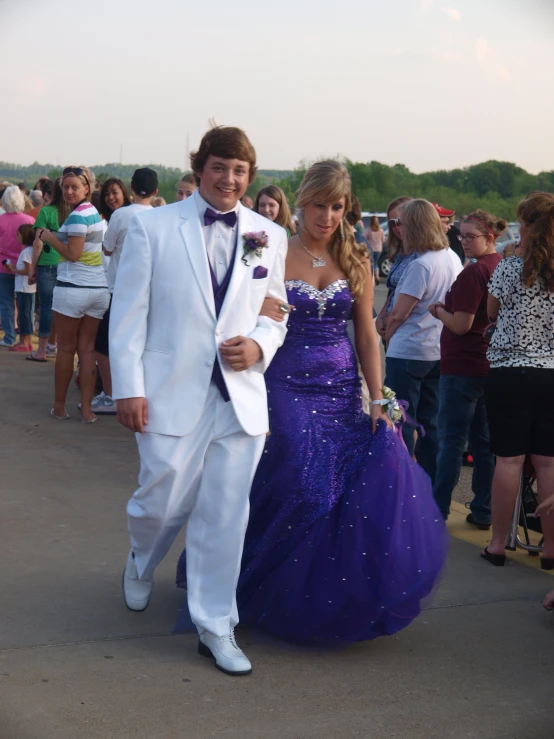 a man and a woman in formal wear in front of people