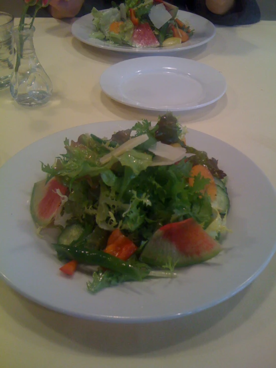 a plate of salad and salad dressing on a table