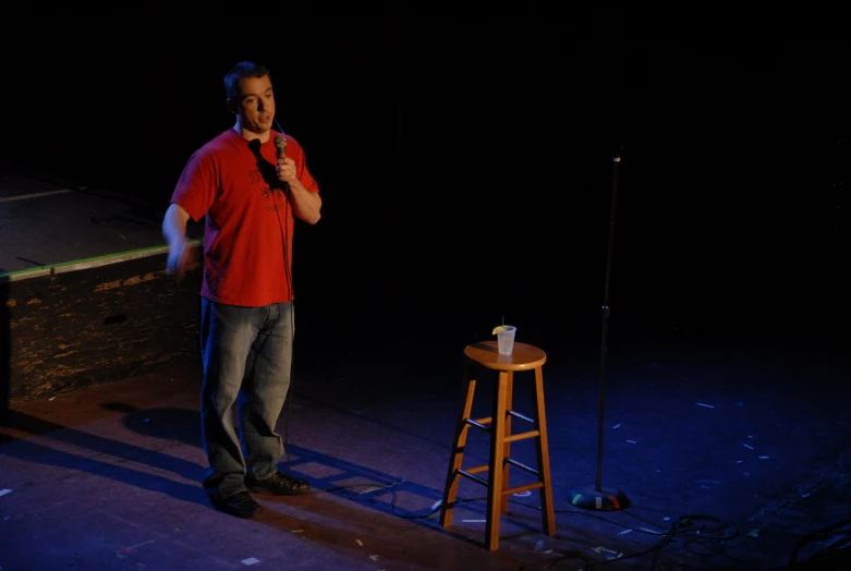 a man standing next to a chair in a dark room