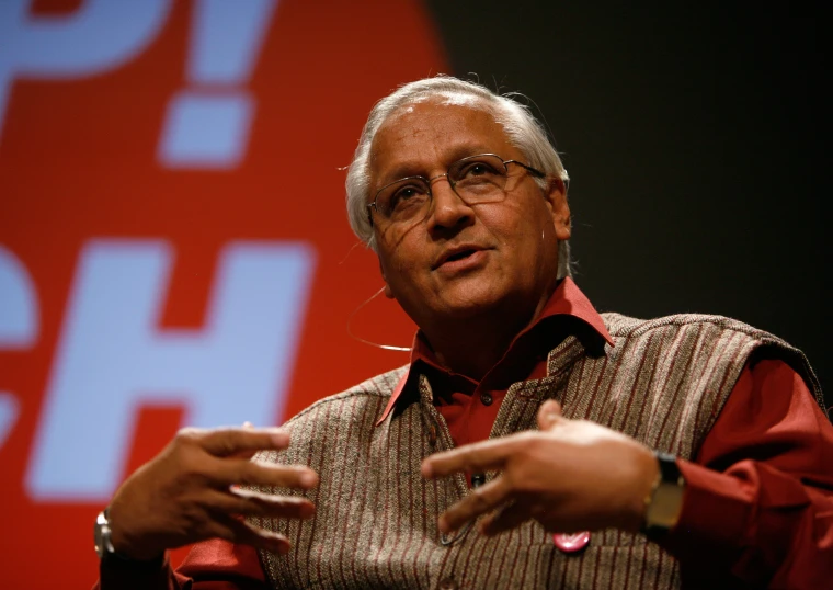 a man giving a speech in front of a screen