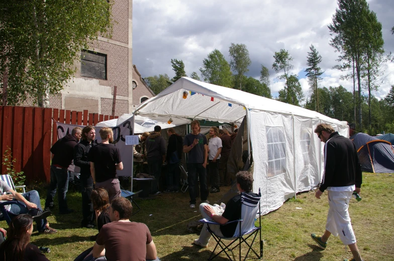 a tent full of people sitting and walking around outside