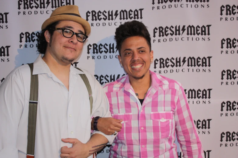 two men standing together on a red carpet at an event