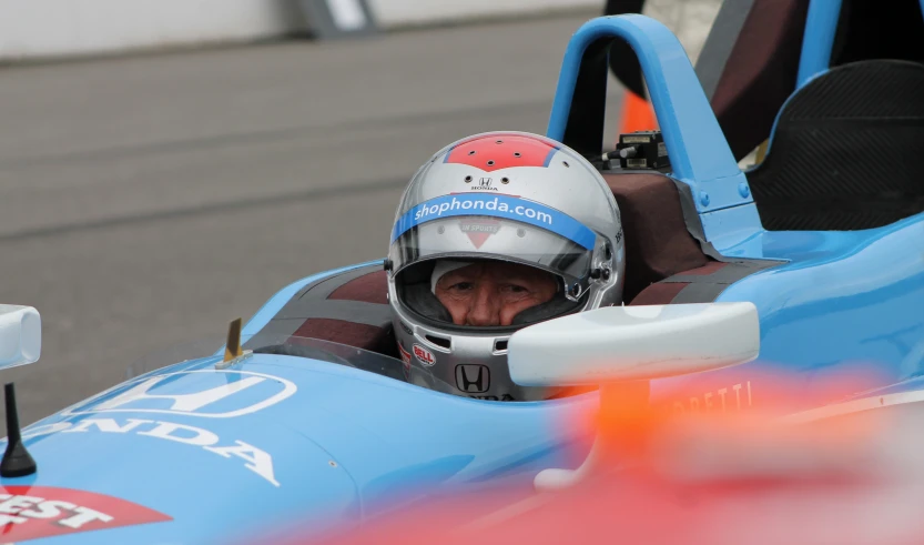 a person in a racing car with a helmet