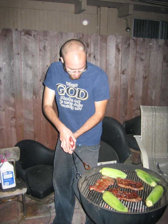 man making food over the fire outside at night