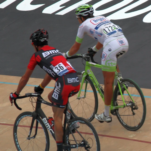 two men on bicycles one with an extra helmet