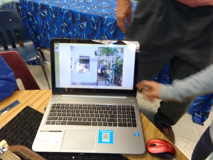 two people at a table are working on a laptop computer