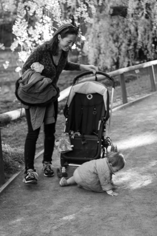 a woman standing next to a child in a stroller
