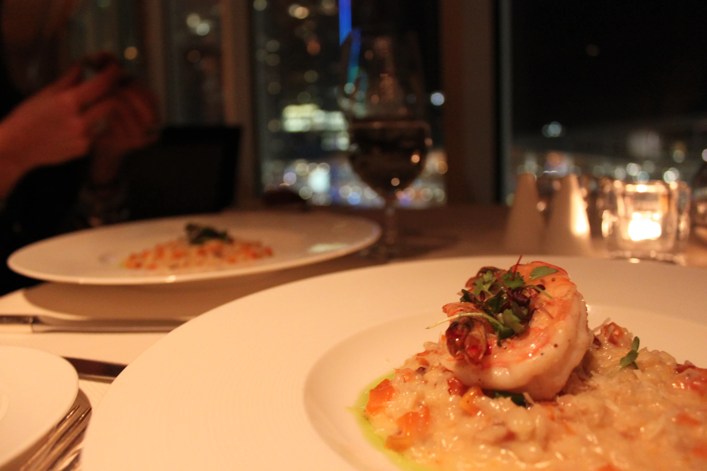 a plate of food with shrimp on top, and another dish