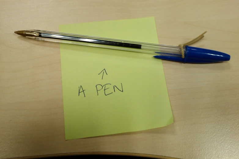 the blue fountain pen has been placed on top of a piece of yellow paper