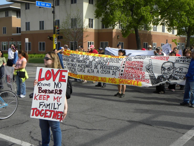 people standing around holding signs and holding bikes