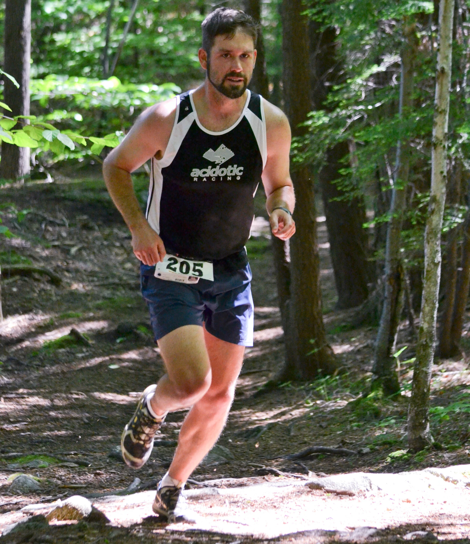 a man running through a forest on a trail