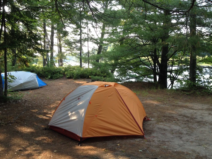 two tents pitched on top of a dirt ground