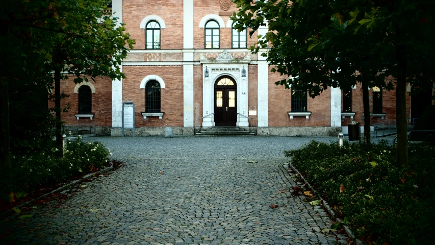 the entrance to the red brick building with cobblestone walkway