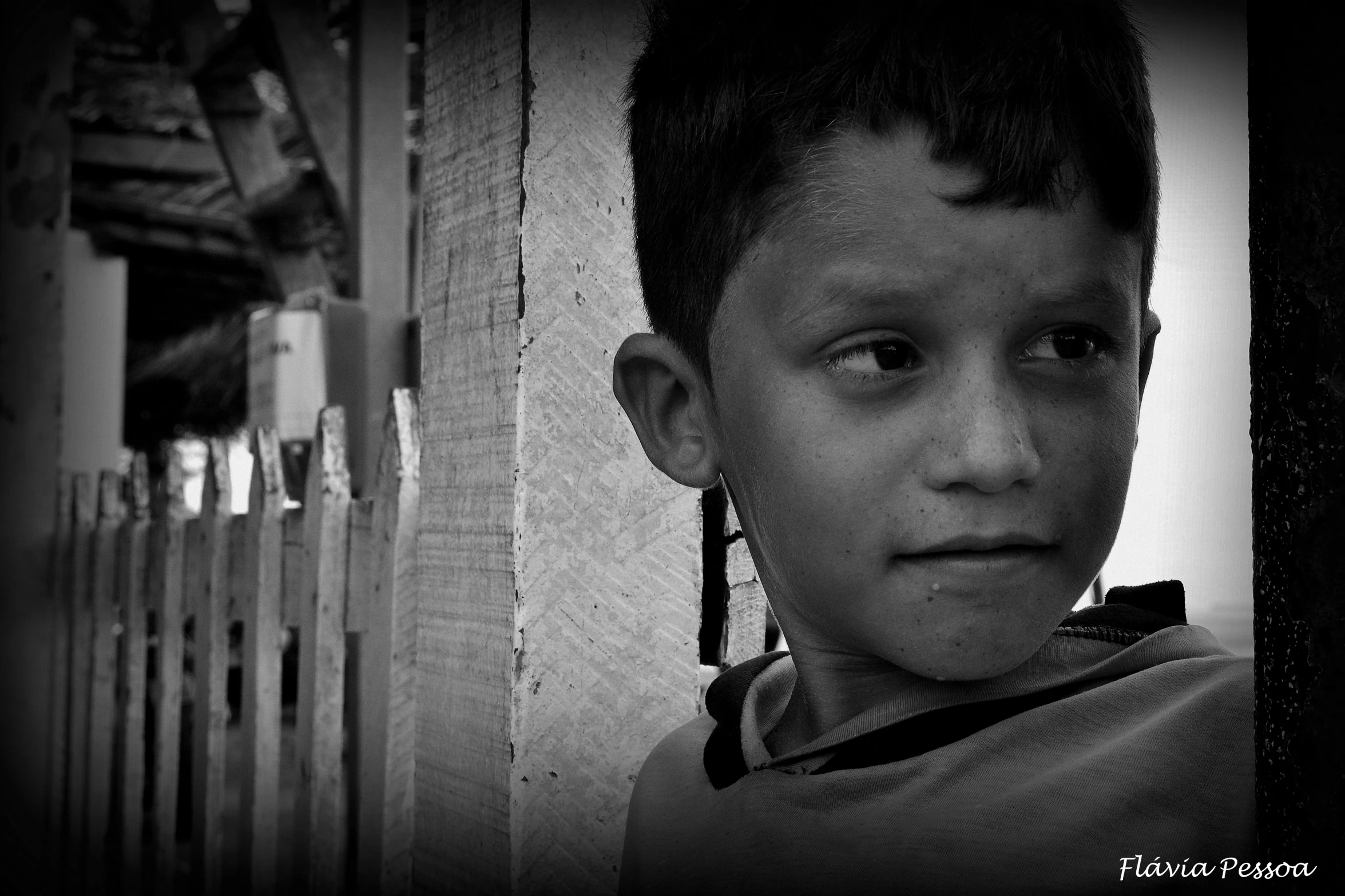 a boy with a sad face standing against a wall