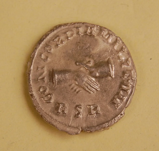 a roman coin is on the table and it is in brown paper