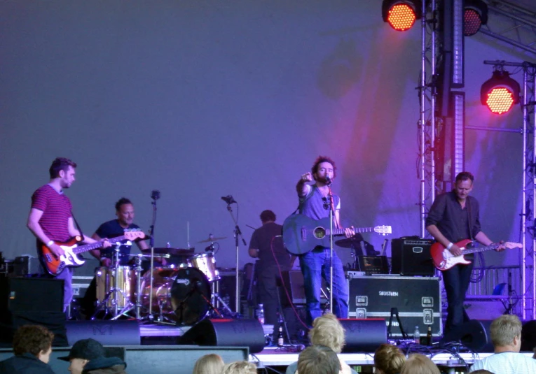 several guys are performing at an event in front of a crowd