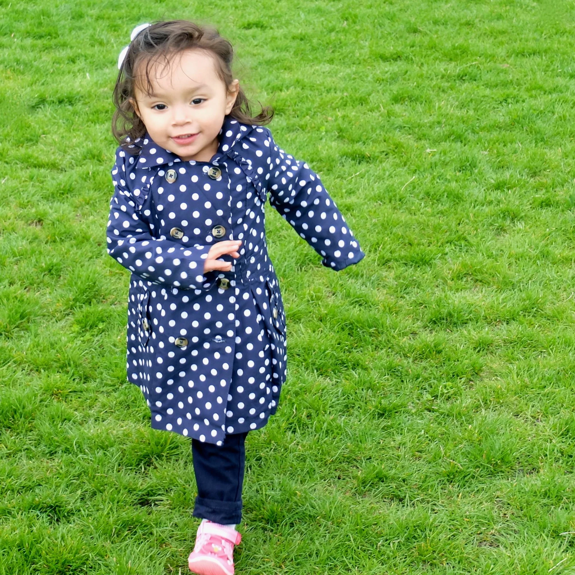 a young child walks on some green grass