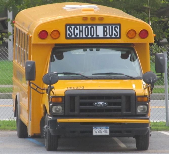 a school bus parked next to a chain link fence
