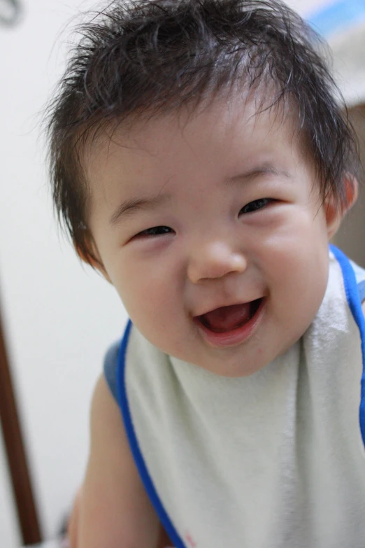 a child wearing a shirt and smiling at the camera