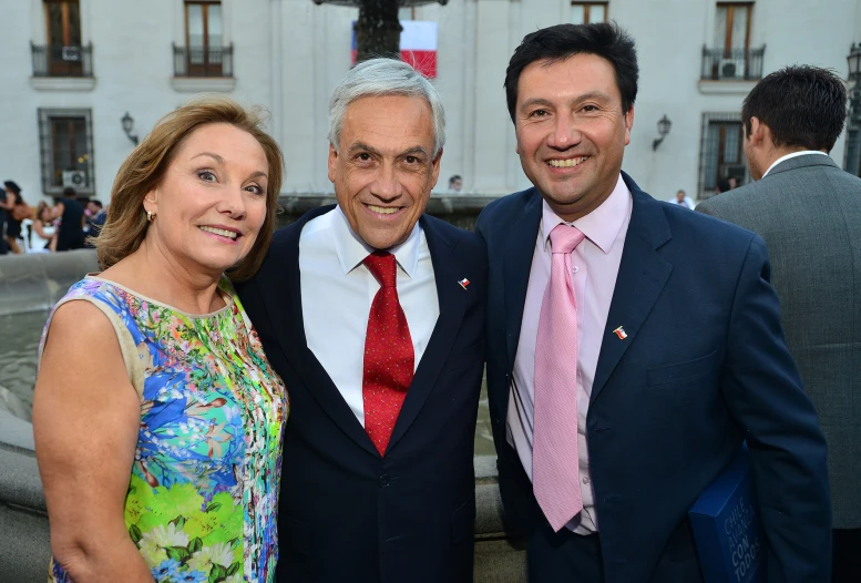 three people posing together for a po in front of some buildings