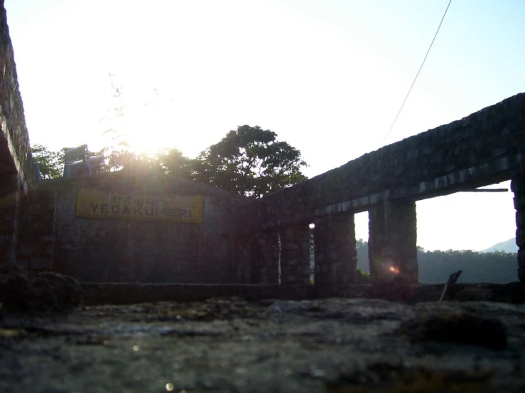 a po taken from behind of an old building, with the sun shining brightly through