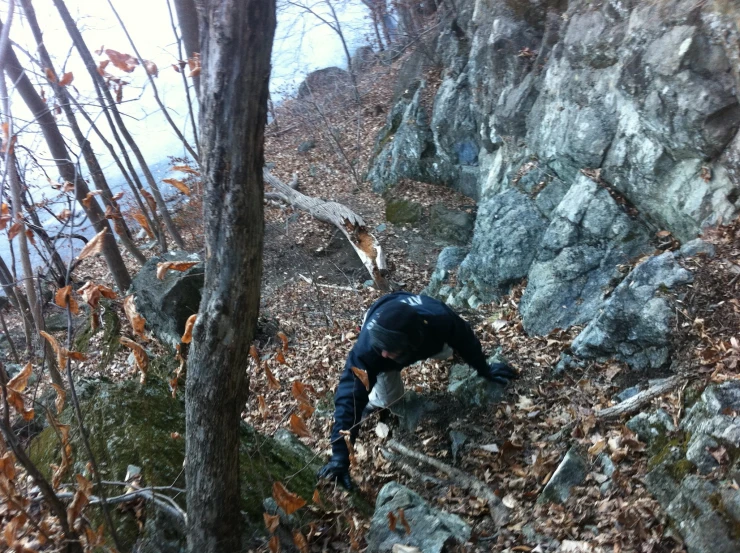 a man is standing next to a rocky area