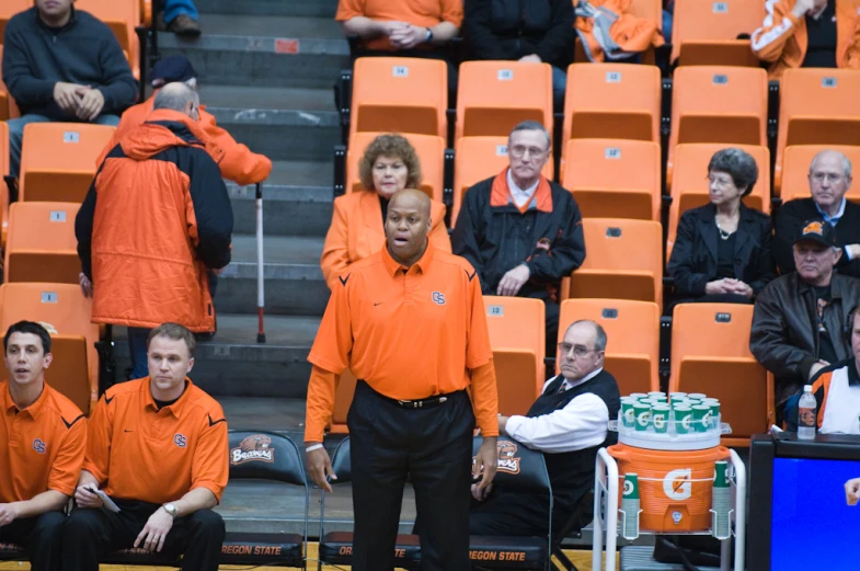 a man in an orange shirt and some people watching him