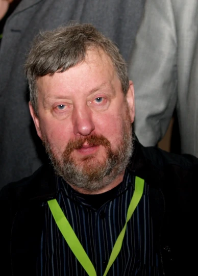 a man with a beard and a collar is looking at the camera