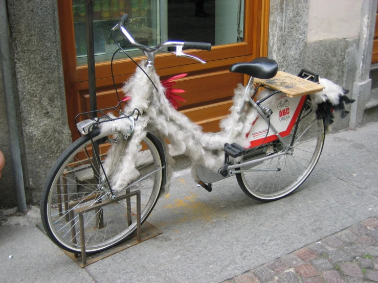 a bike parked next to a building with fur on it