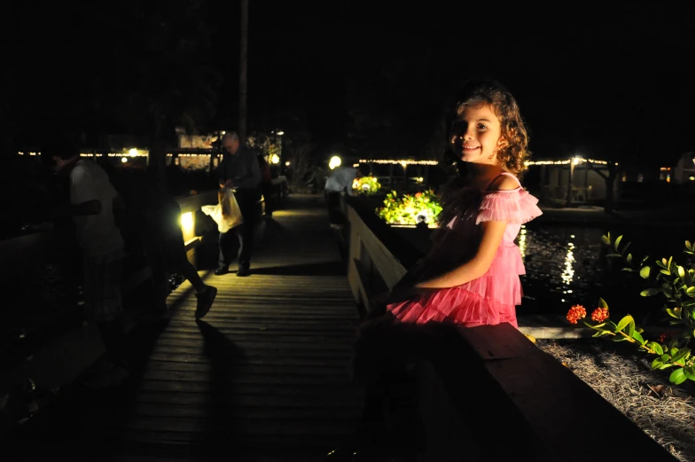 woman wearing pink on the boardwalk at night