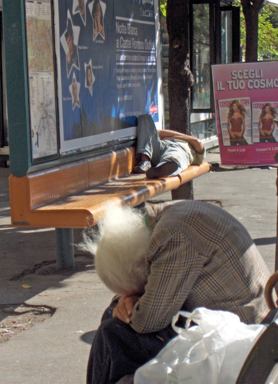 an old woman bends down to talk on the phone