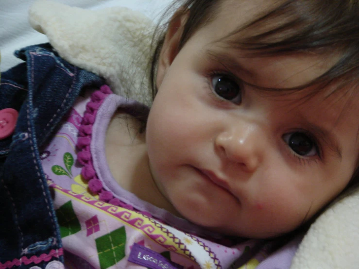 a close up of a little girl wearing a stuffed animal