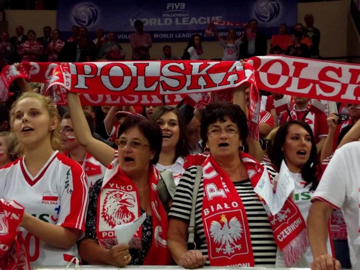 people holding signs and scarves watching a soccer match