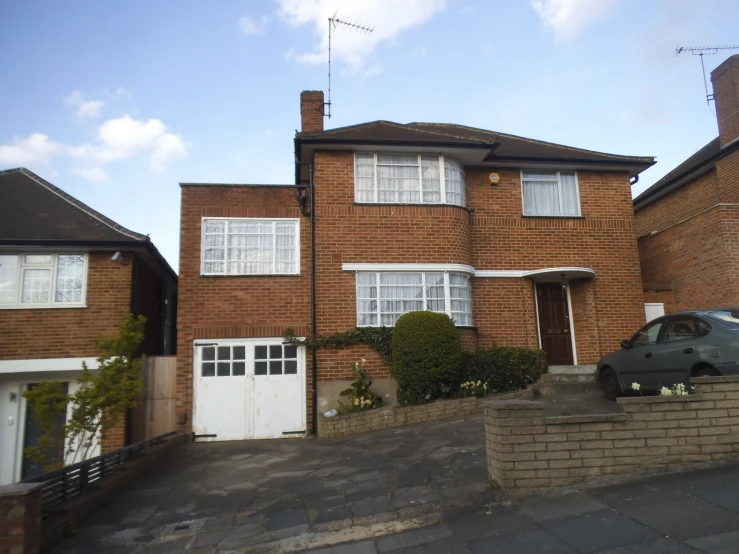 this two - story brick house is next to an attached driveway