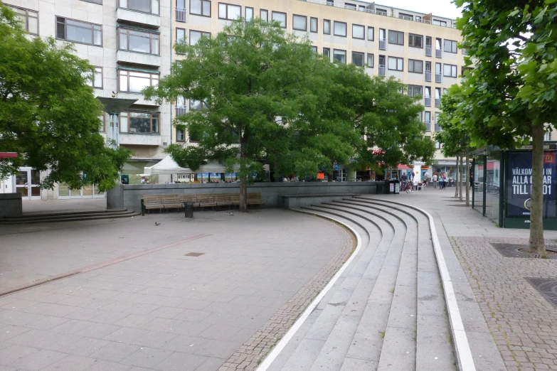 an empty street surrounded by a building and trees