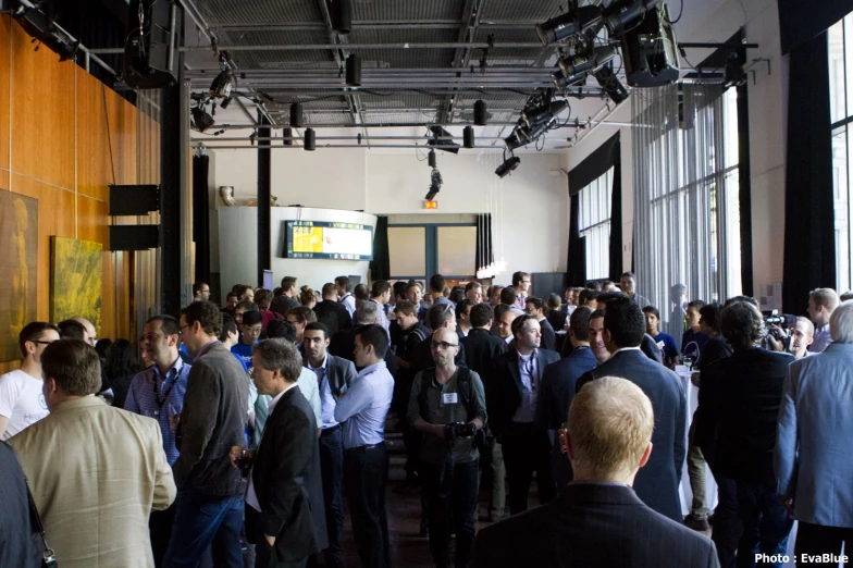 a large crowd of people standing in front of large windows