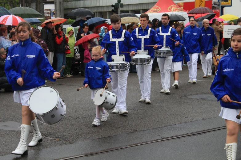 s on drums in parade at outdoor gathering