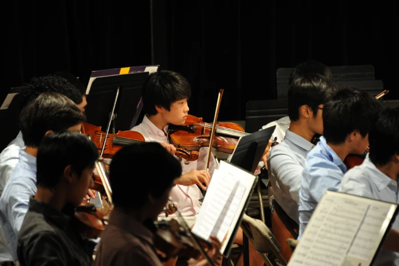 a conductor watching his orchestra play some instruments