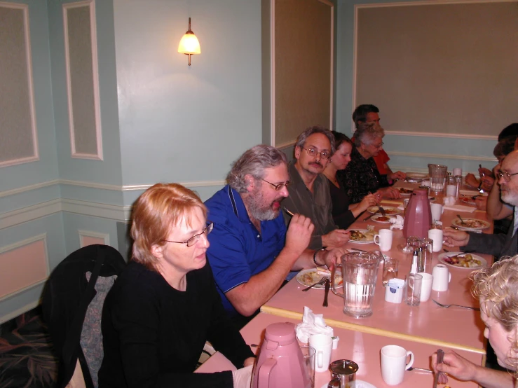 a group of people sitting at a long table