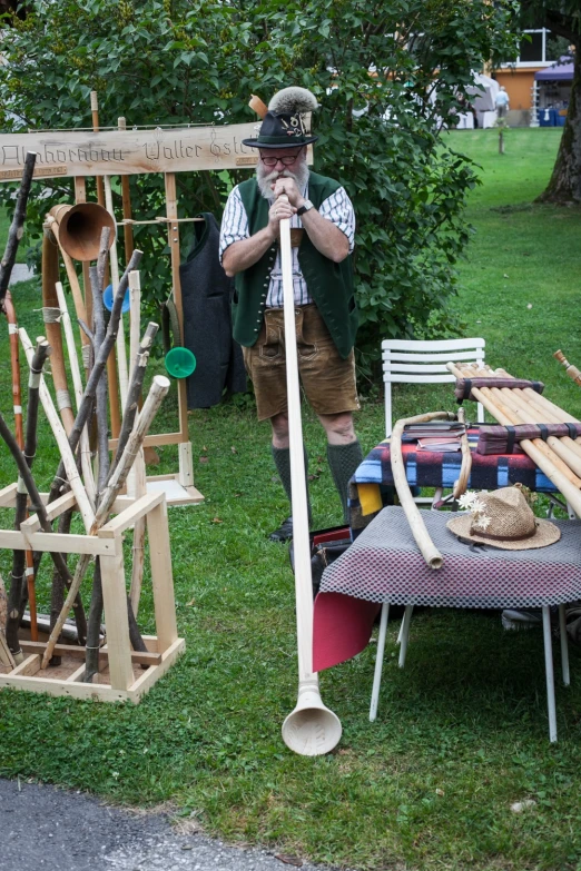 a man with a giant paddle stands by a lot of outdoors items