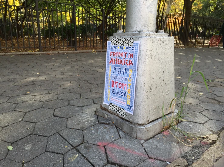 the pole with signs is on the sidewalk next to the fence