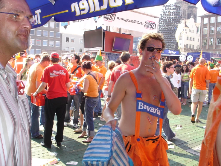 a group of men with towels under a canopy in a crowd