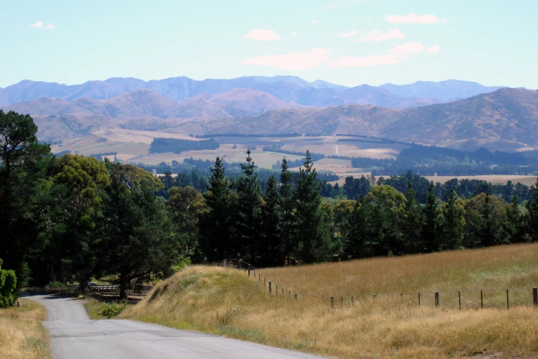 a dirt road passes the mountains in the distance