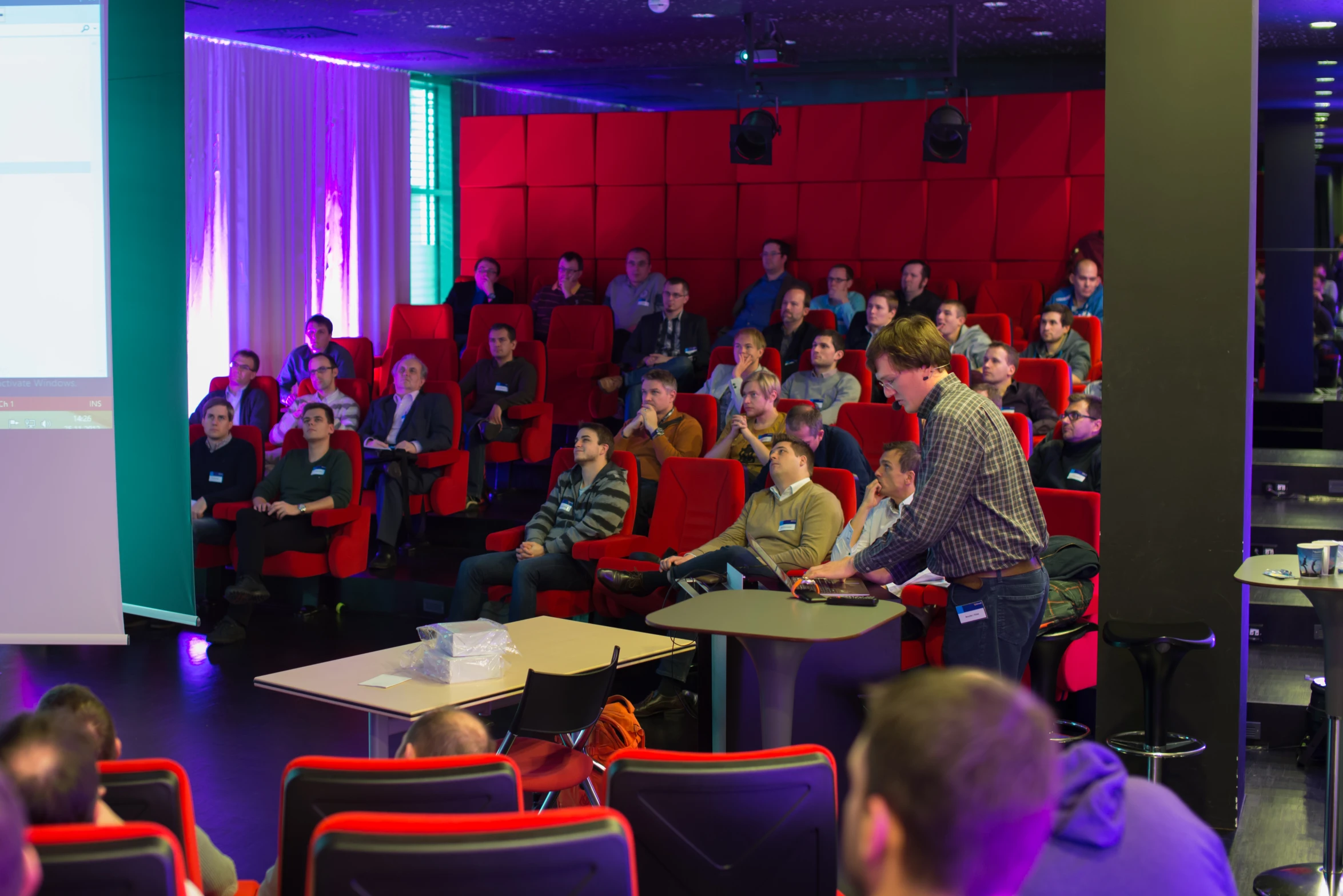 an audience in a lecture hall listening to speakers