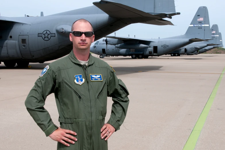 a man in a green uniform is standing in front of a large plane