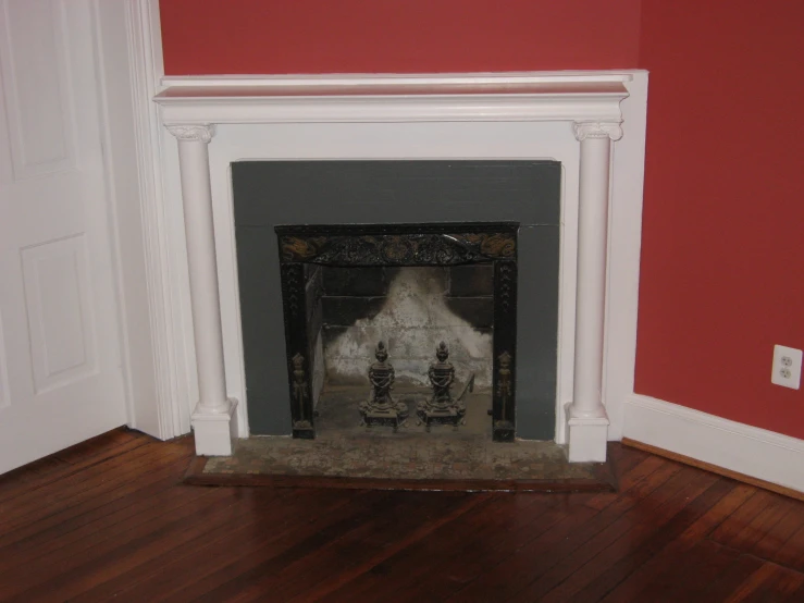 a fire place in a room with red painted walls