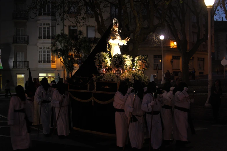 a group of women in robes standing around a statue