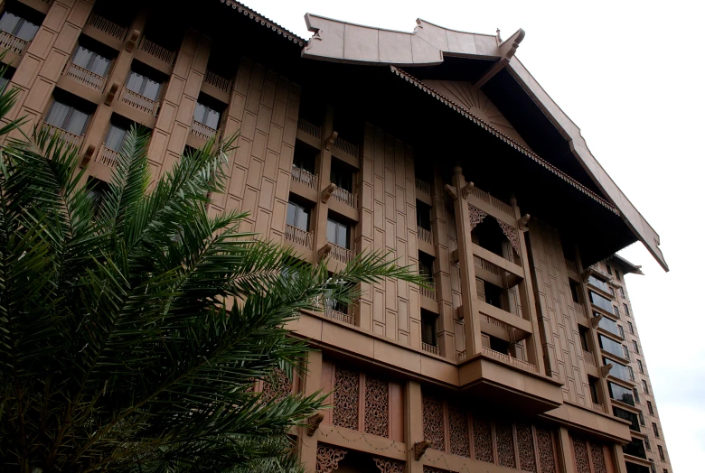 a brown building with an intricate pattern and palm trees