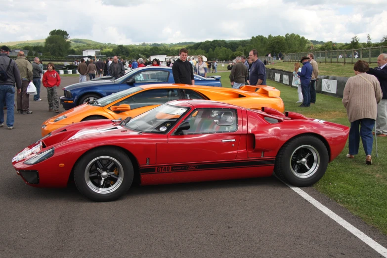 two racing cars parked near other cars in a parking lot